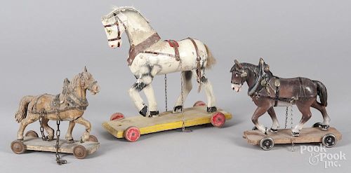 Three horse pull toys on platforms