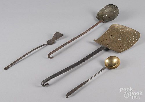 Four wrought iron and brass kitchen utensils.