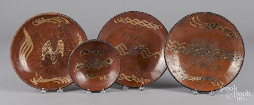 Four slip decorated redware plates