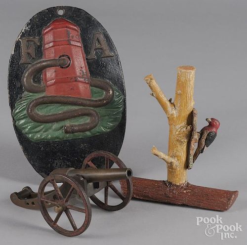Cast iron firemark, a bronze cannon and woodpecker