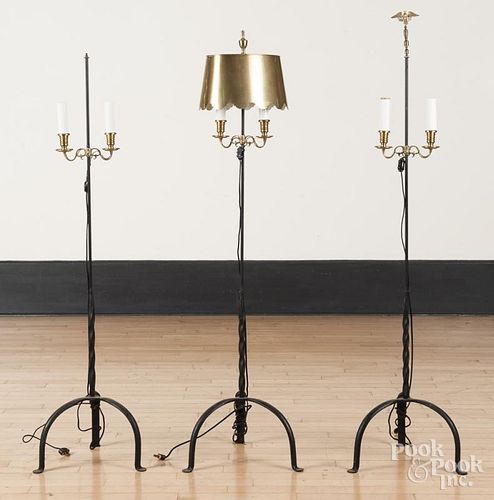 Three iron and brass floor lamps.