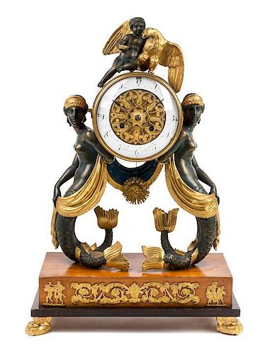 * An Austrian Carved and Parcel Gilt Empire Mantel Clock Height 22 x width 15 1/4 inches.