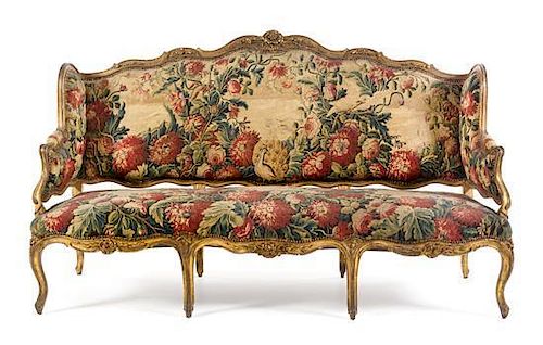* A Louis XV Giltwood Canape a Oreilles Height 45 1/8 x width 76 x depth 25 1/2 inches.