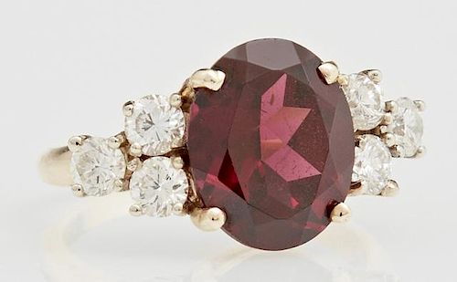 Lady's 14K Yellow Gold Dinner Ring, with an oval 5 carat garnet, flanked by three round 10 point diamonds on each side, total