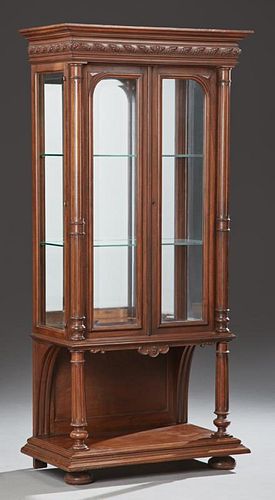 French Henri II Style Carved Walnut Vitrine, late 19th c., the stepped crown over setback double wide beveled glazed doors, f