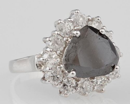 Lady's 14K White Gold Dinner Ring, with a 5.75 carat pear shaped black diamond, atop a conforming border of round diamonds, t