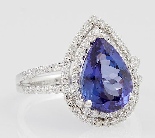Lady's Platinum Dinner Ring, with a 4.84 carat pear shaped tanzanite atop two pierced concentric graduated borders of small r