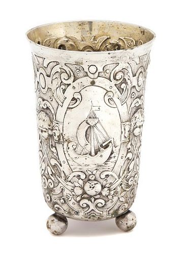 A Continental Silver Tumbler, 19th Century, decorated with masks and oval cartouches of a dolphin, a landscape, and a sailboa