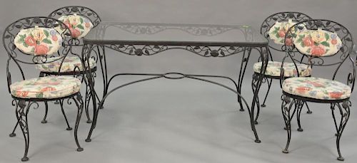 Five piece wrought iron glass top table and four chairs with cushions. ht. 29 in., top: 31" x 51"