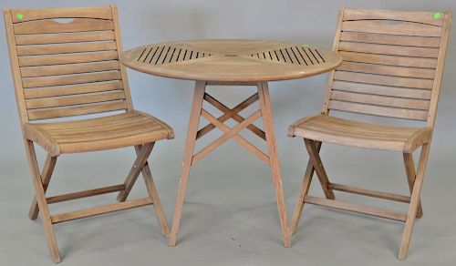 Three piece teak lot including round table and two chairs. ht. 29 in., dia. 36 in.