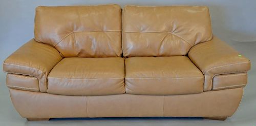 Natuzzi leather loveseat, light brown with white threading. lg. 76 in.
