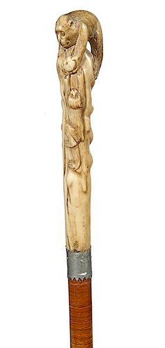 51.Japanese Stag Cane- Ca. 1890- A carved stag handle with father and baby primates playing with a fruit, saw tooth metal co