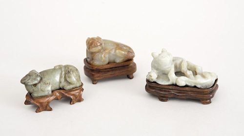THREE CHINESE CARVED JADE FIGURES OF RECLINING FELINES
