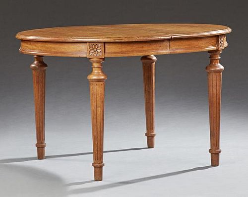 French Louis XVI Style Carved Oak Dining Table, 20th c., the oval stepped edge opening to accept leaves, on a wide skirt, on 