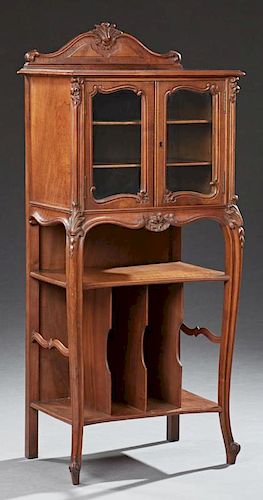 French Louis XV Style Carved Walnut Music Cabinet, early 20th c., the arched leaf carved backsplash over a stepped top above 