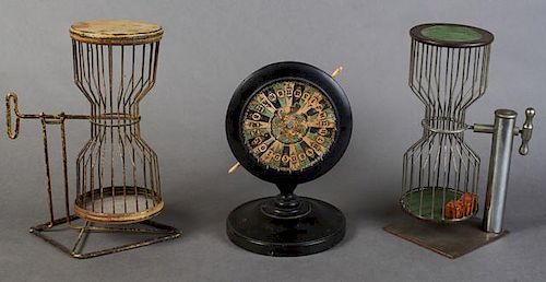 Group of Three Antique Gambling Devices, consisting of two iron cage dice tumblers, and a miniature wood spinning wheel, on a
