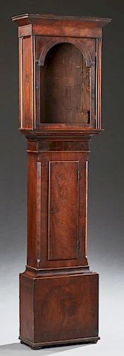 Georgian Carved Mahogany Clockcase, early 19th c., the stepped slanted crown over an arched door above a pendulum door, on a 