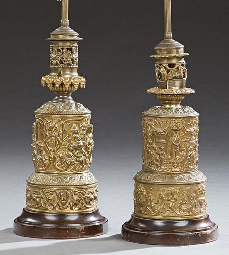 Near Pair of Brass Repousse Parcel Lamps, 19th c., with frolicking putti decoration, on turned wooden bases, now electrified,
