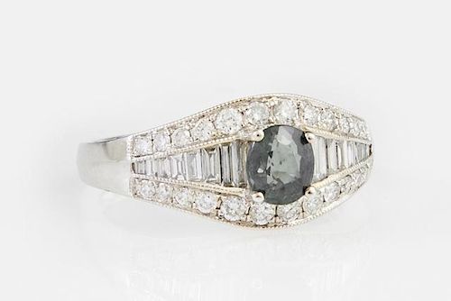 Lady's 18K White Gold Dinner Ring, with an oval green .94 carat sapphire flanked by a central row of graduated baguette diamo