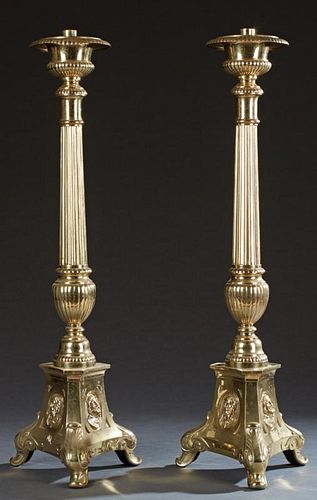 Pair of Large Brass Altar Candlesticks, 20th c., on reeded knopped supports, to triangular sloping bases with relief decorati