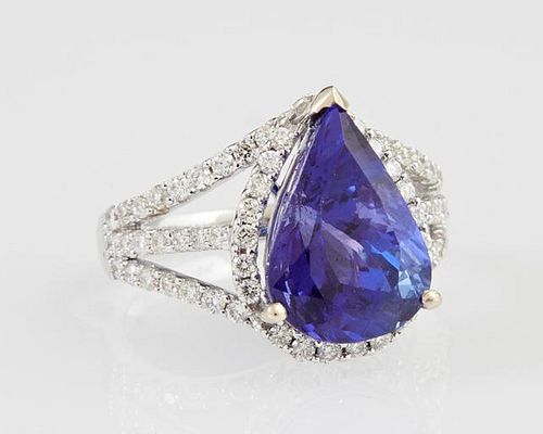 Lady's 18K White Gold Dinner Ring, with a 6.13 carats pear shaped tanzanite atop a border of small round diamonds, the pierce