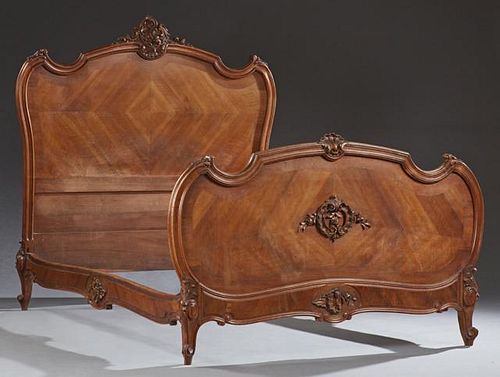 French Louis XV Style Carved Mahogany Bed, early 20th c., the arched headboard with a scroll and floral crest over inset crot