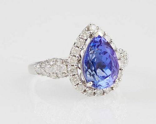 Lady's 14K White Gold Dinner Ring, with a pear shaped 3.74 carat tanzanite above a conforming border of round diamonds, the b