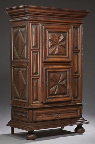 French Louis XIII Style Carved Walnut Armoire, 19th c., the stepped crown over a geometric carved cupboard door above a like 