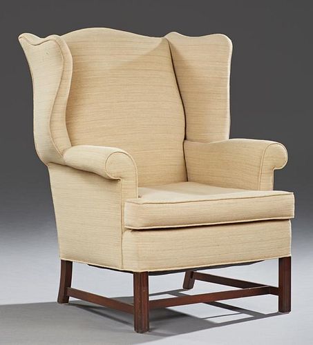 Georgian Style Carved Mahogany Wing Chair, 20th c., the arched back over a loose cushion seat, on square reeded legs joined b