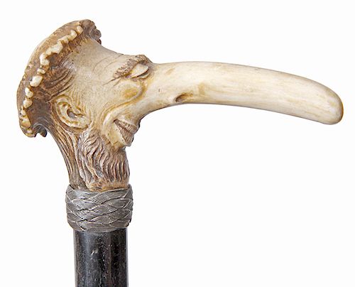 151. Anti-Semitic Stag Cane- early 20th century-  nicely carved antler, woven silver collar, ebonized shaft and a metal ferrule. H.- 4” x 2 ½” O.L. 34
