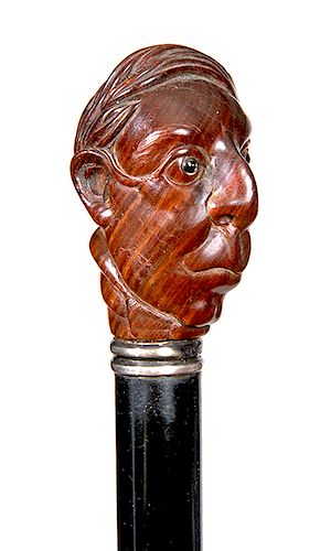 185. Character Cane- Ca. 1930- A carved gentlemen with a wild hair style and two color glass eyes, small silver collar, ebony shaft and brass ferrule.