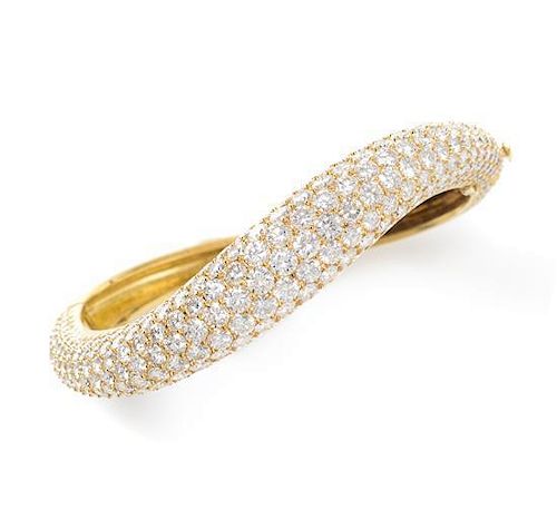 An 18 Karat Yellow Gold and Diamond Pave Bangle Bracelet, 24.95 dwts. in an asymmetric curved design, containing 289 round brill
