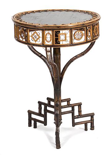 A Victorian Style Bamboo and Ebonized Occasional Table Height 29 x diameter 21 inches.