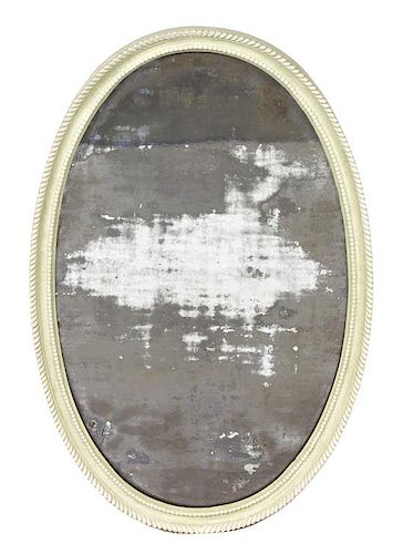 A Carved and Green Painted Oval Mirror Height 39 1/2 x width 24 inches.