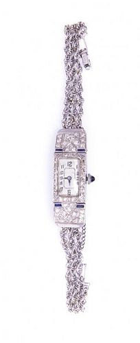 A Platinum, White Gold, Diamond and Synthetic Sapphire Wristwatch, 12.70 dwts.