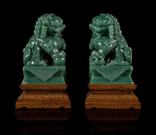 A Pair of Chinese Green Jade Figures of Fu Lions Height 6 1/4 inches.