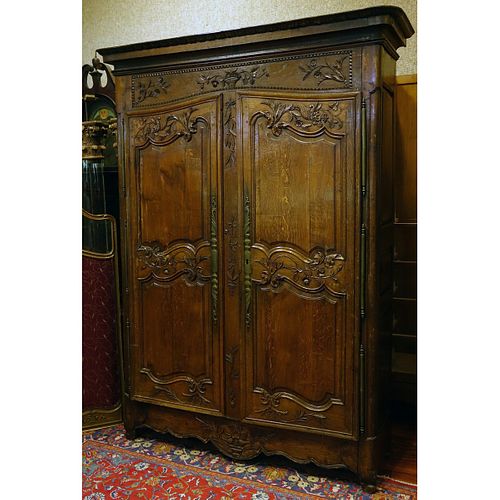 Early 19th Century Louis XV Style Carved Oak Armoire with Bronze Mounts. Carved with baskets, urns, flowers and leaf work throughout the surface.