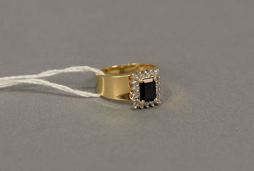 14 karat yellow gold diamond and sapphire ring, sapphire dark blue in color, emerald cut 6.7 x 5.0mm, with 18 diamonds around .10 ca...