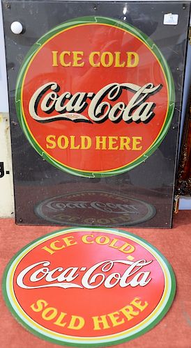 Three Coca Cola tin signs including two "ice Cold Coca-Cola Sold Here" round signs and a Coca Cola It's the Real Thing Coke sign. fi...