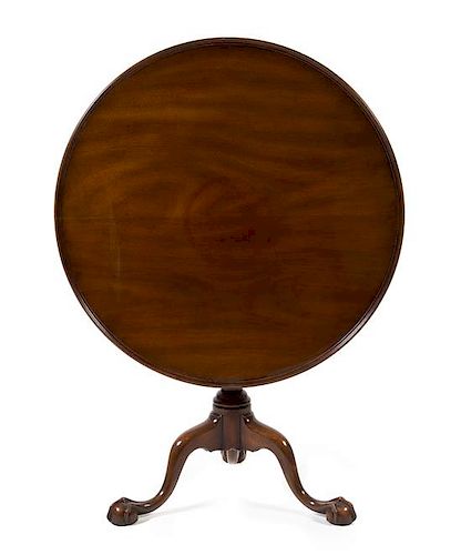 A Queen Anne Style Mahogany Tilt-Top Table Height 28 3/4 x diameter of top 34 1/2 inches.