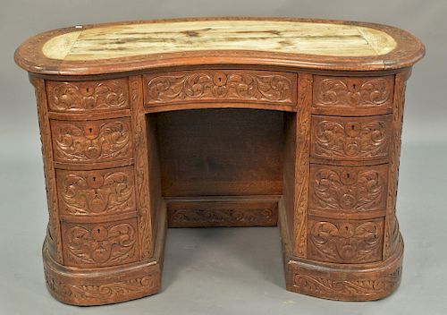 Oak kidney shaped desk, overall carved (leather writing surface missing). ht. 30in., wd. 47in.