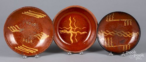 Three slip decorated redware plates/shallow bowls