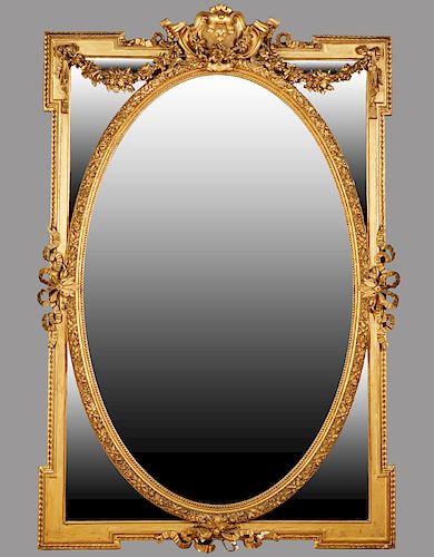 Louis XV Style Gilt and Gesso Overmantle Mirror, 20th c., with a floral shield crest above two floral garlands over a central oval wide beveled plate,