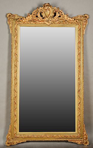 French Louis XV Style Gilt and Gesso Overmantle Mirror, 19th c., with a pierced scrolled relief crest over a rounded frame with relief leaves and flow