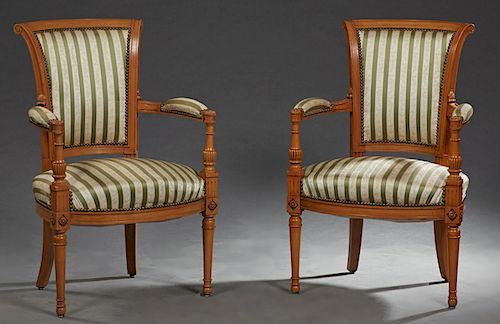 Pair of French Directoire Style Carved Cherry Fauteuils, 20th c., the scrolled carved crest rail above upholstered backs flanked by upholstered arms a