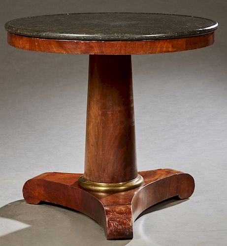 French Empire Marble Top Mahogany Center Table, 19th c., the dished black marble over a wide skirt on a tapered cylindrical support on an ormolu mount