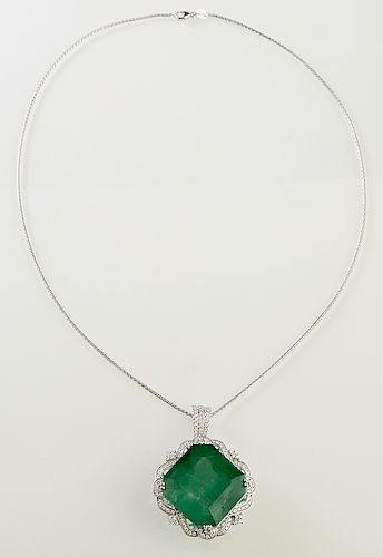 Lady's Platinum Pendant, with a 68.17 carat emerald atop a pierced loop border mounted with round diamonds, the tapered bale with three parallel rows 
