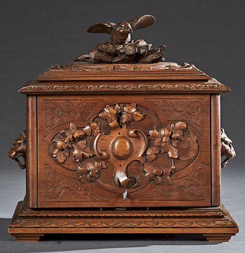 French Black Forest Style Carved Walnut Cave a Liqueur, late 19th c., the lid with a high relief carved sparrow on leaves, over a folding front carved