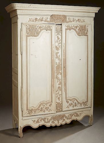 French Louis XV Style Polychromed Oak Armoire, c. 1850, the rounded corner crown centered by relief carved floral bouquet over arched double doors cen