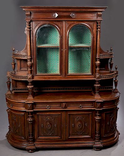 Large French Henri II Style Carved Walnut Sideboard, c. 1880, the stepped crown over setback double arched beveled glass doors flanked by turned colum